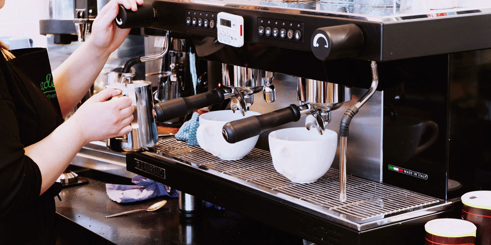 Person marking espresso at espresso machine